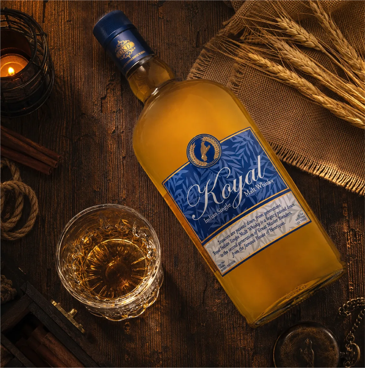 Koyal whisky bottle beside a glass and grain